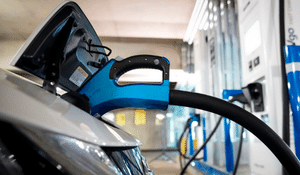 grey vehicle hooked into blue ev charging station