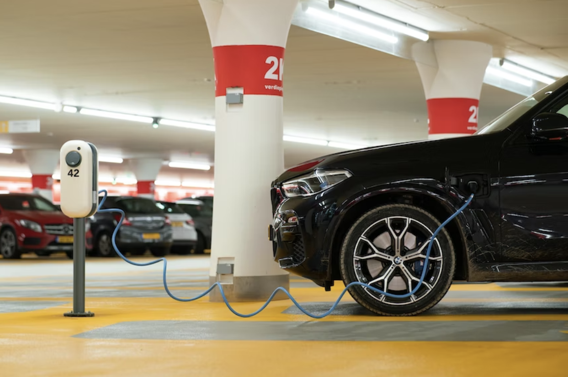 black car charging in hotel parking lot 